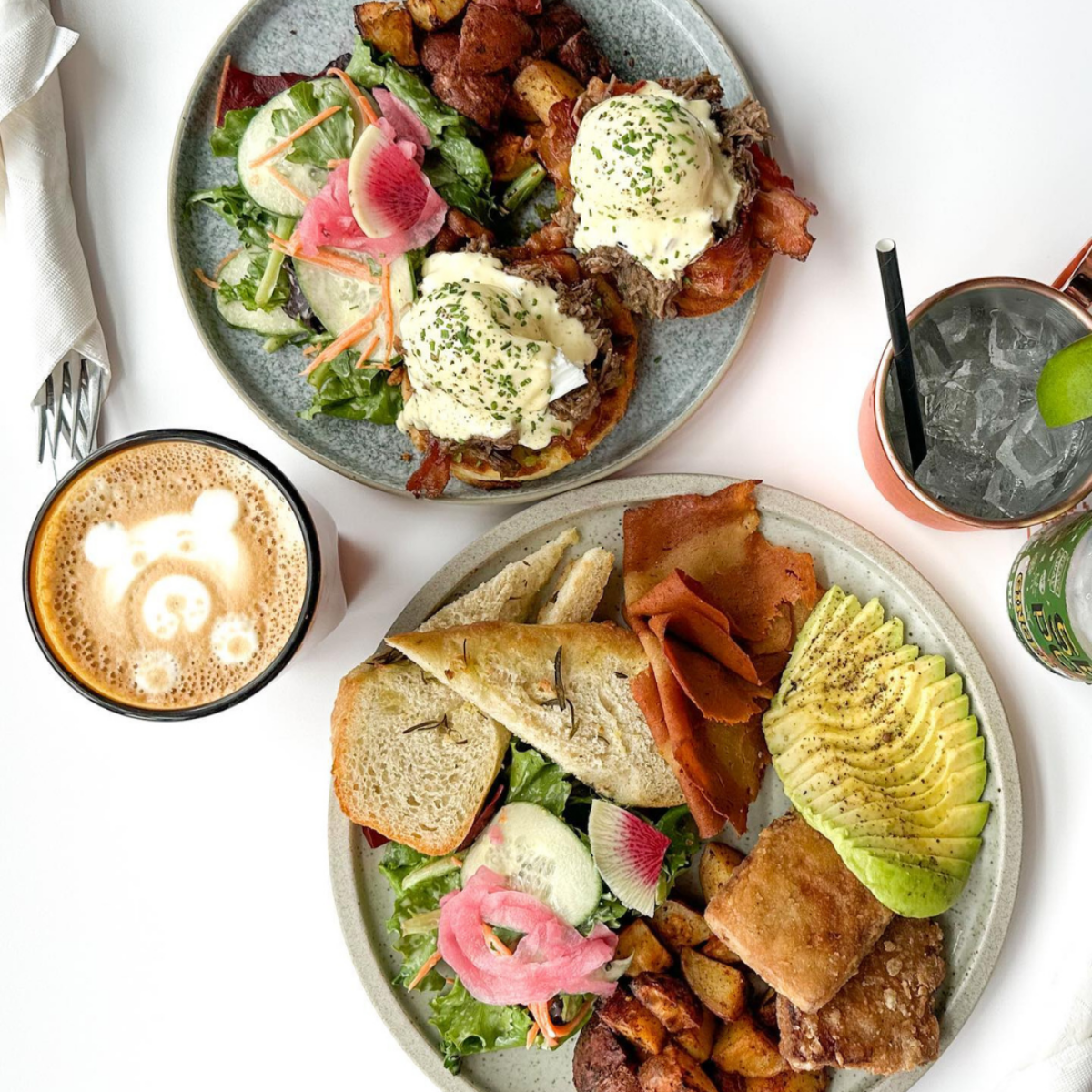 Brunch plates with eggs Benedict, avocado, salad, and latte in Halifax