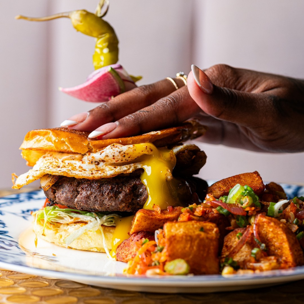 Breakfast sandwich served with crispy potatoes