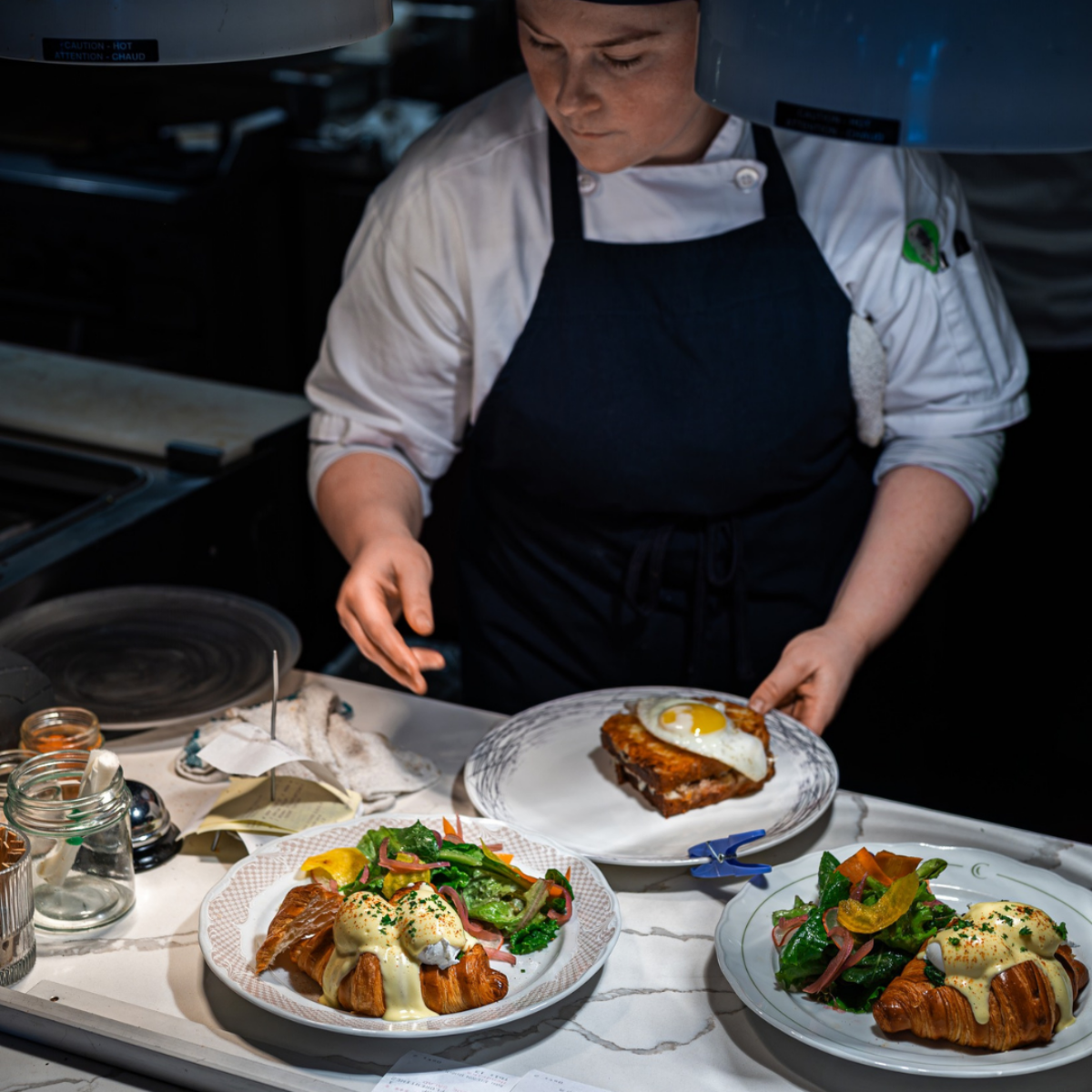 Chef plating elegant brunch dishes in a bright kitchen at a Halifax restaurant